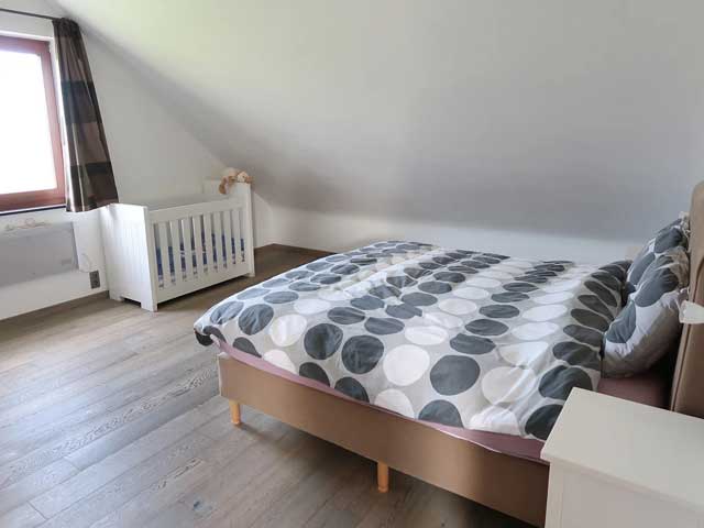 Villa in Érezée slaapkamer met 2-persoons bed en babybedje